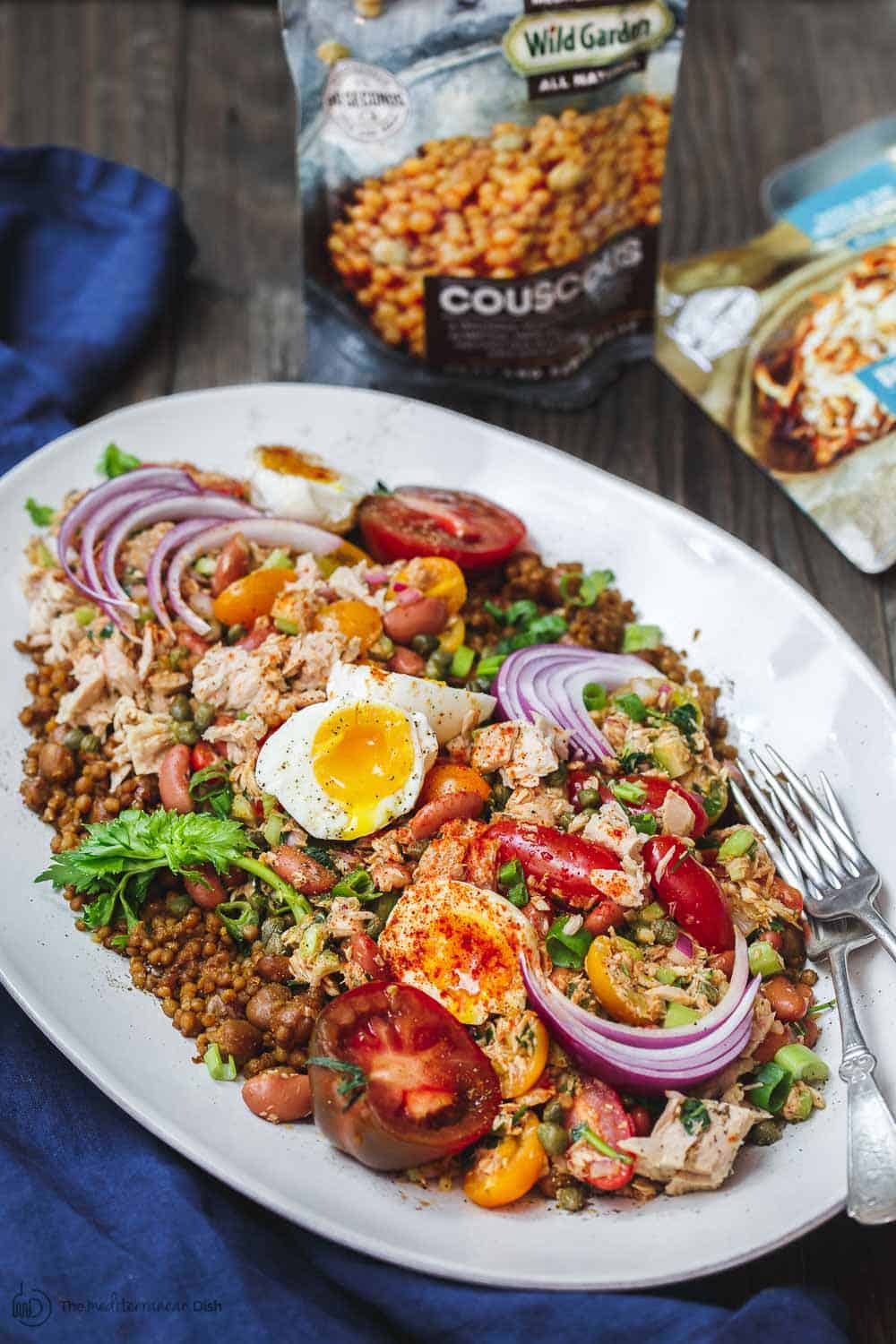 Tuna Couscous Salad Recipe | The Mediterranean Dish. Canned tuna takes on an Italian twist with kindey beans, fresh veggies, capers and more! Add heat and ready couscous pilaf from @wildgardenfoods for an easy weeknight dinner! See the full recipe on TheMediterraneanDish.com